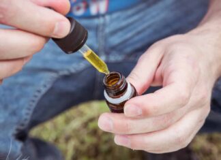 selective focus photography of person holding drop bottle