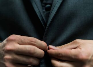 person holding black suit jacket button