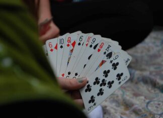 person holding fan of playing cards