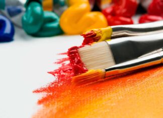 three silver paint brushes on white textile