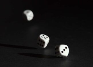 3 white dice on black surface