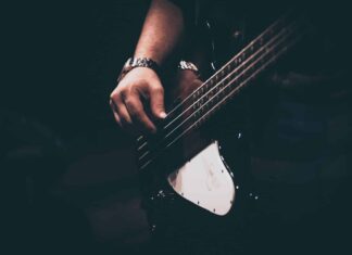 person playing white and black electric guitar