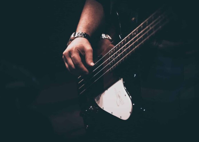 person playing white and black electric guitar
