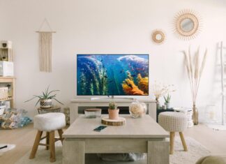 black flat screen tv turned on near white wooden table