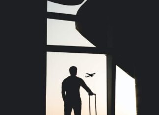 silhouette of man holding luggage inside airport