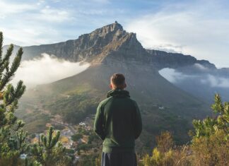 man standing in front of mountain