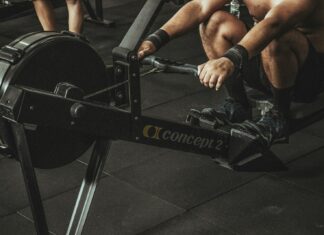 topless man using rowing machine