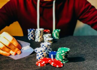 person sitting near poker chips