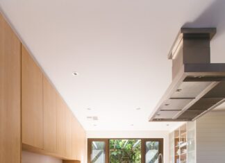 white wooden kitchen island and cupboard cabinets near glass panel door
