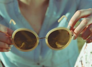 woman holding round sunglasses during daytime